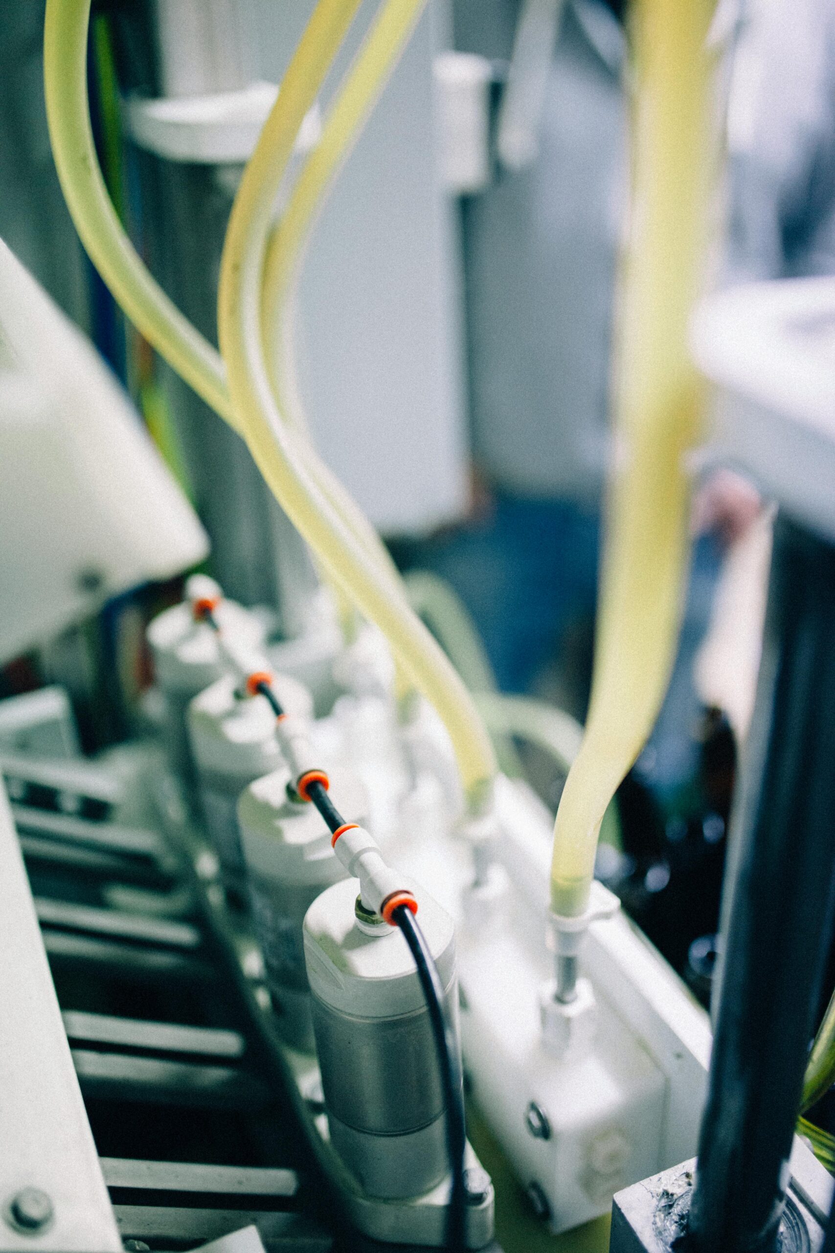 Detailed view of a bottling line in a high-tech brewery focusing on hoses and machinery.